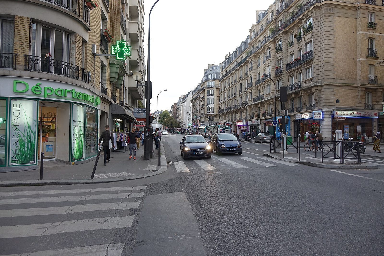 Hjørneapotek med grønt apotekkors i en helt vanlig parisisk bygate