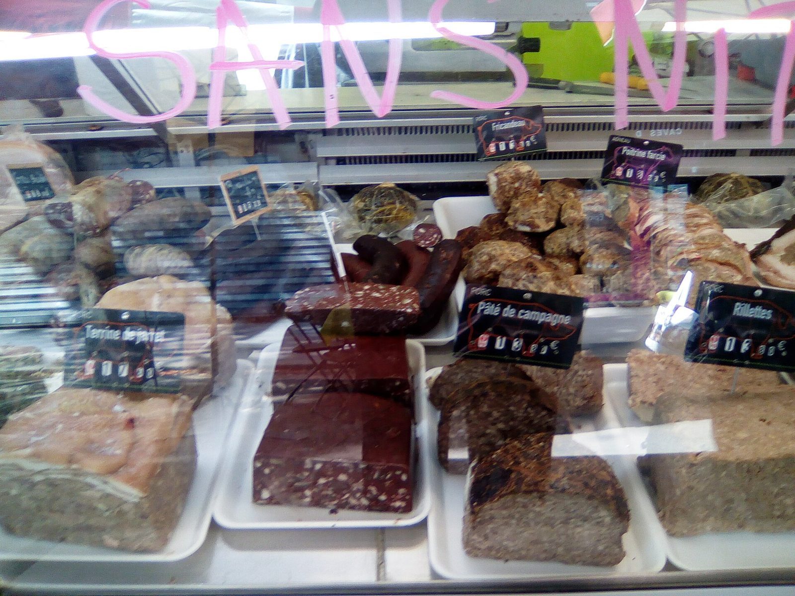 Kjøledisk på et parisisk marked med terrine, pâté de campagne og rillettes merket på små skilt