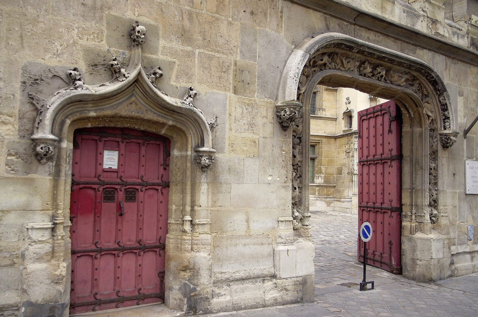 Den sengotiske portalen til Hôtel de Cluny med røde treporter og utskåret steinramme