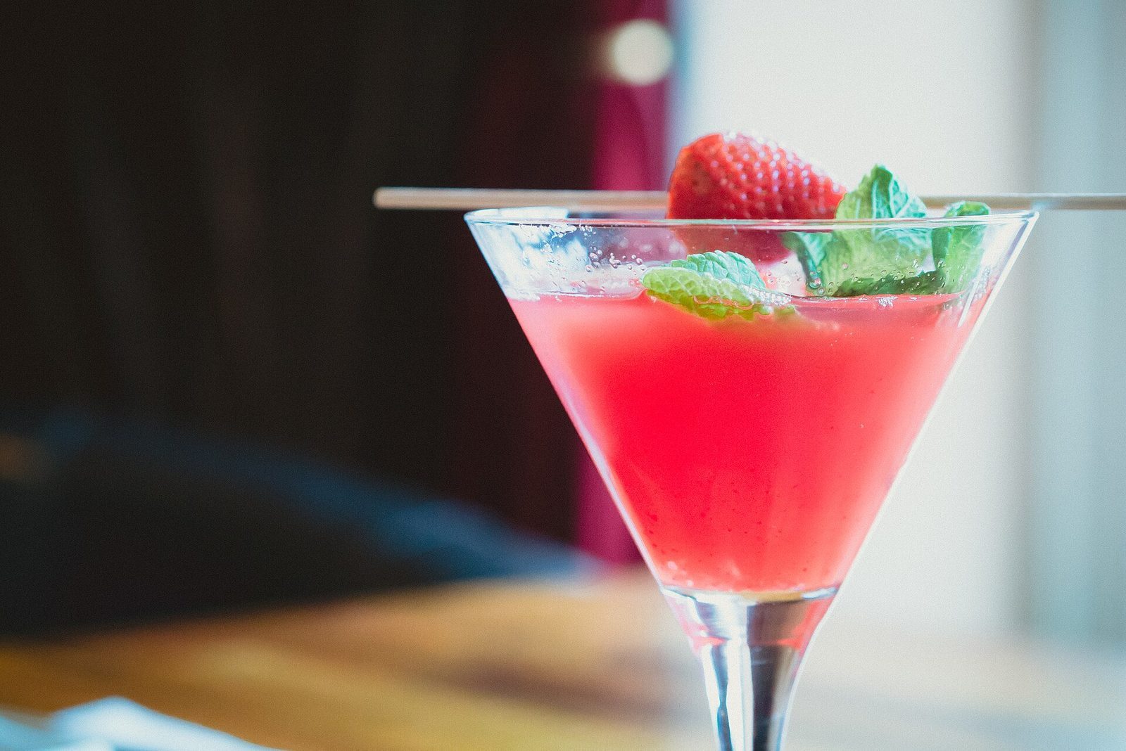 Cocktail med jordbær i et stettglass på en bardisk