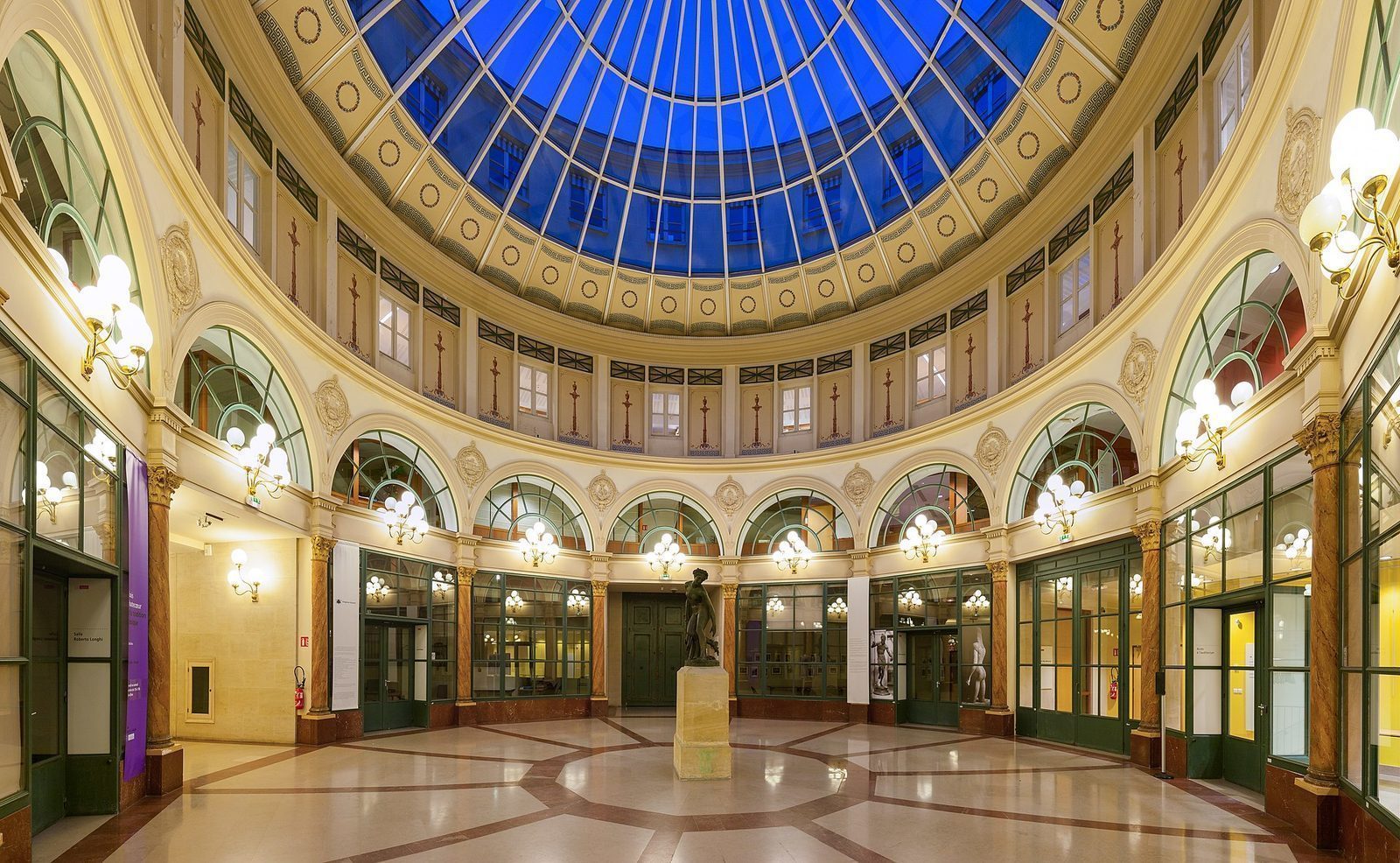Rotunden i Galerie Colbert med glasskuppel, gasslamper i messing og mønstret marmorgulv