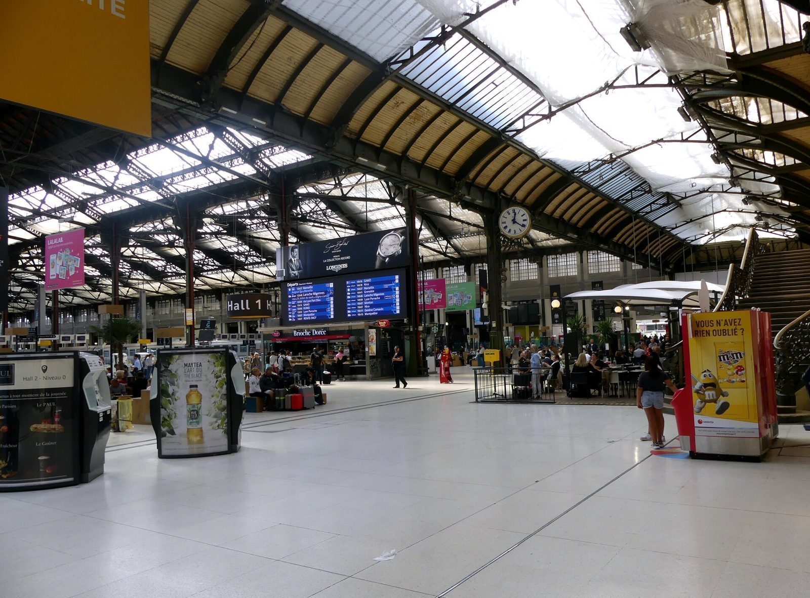 Hall 1 på Gare de Lyon med avgangstavle, stasjonsur og buet jernbanetak