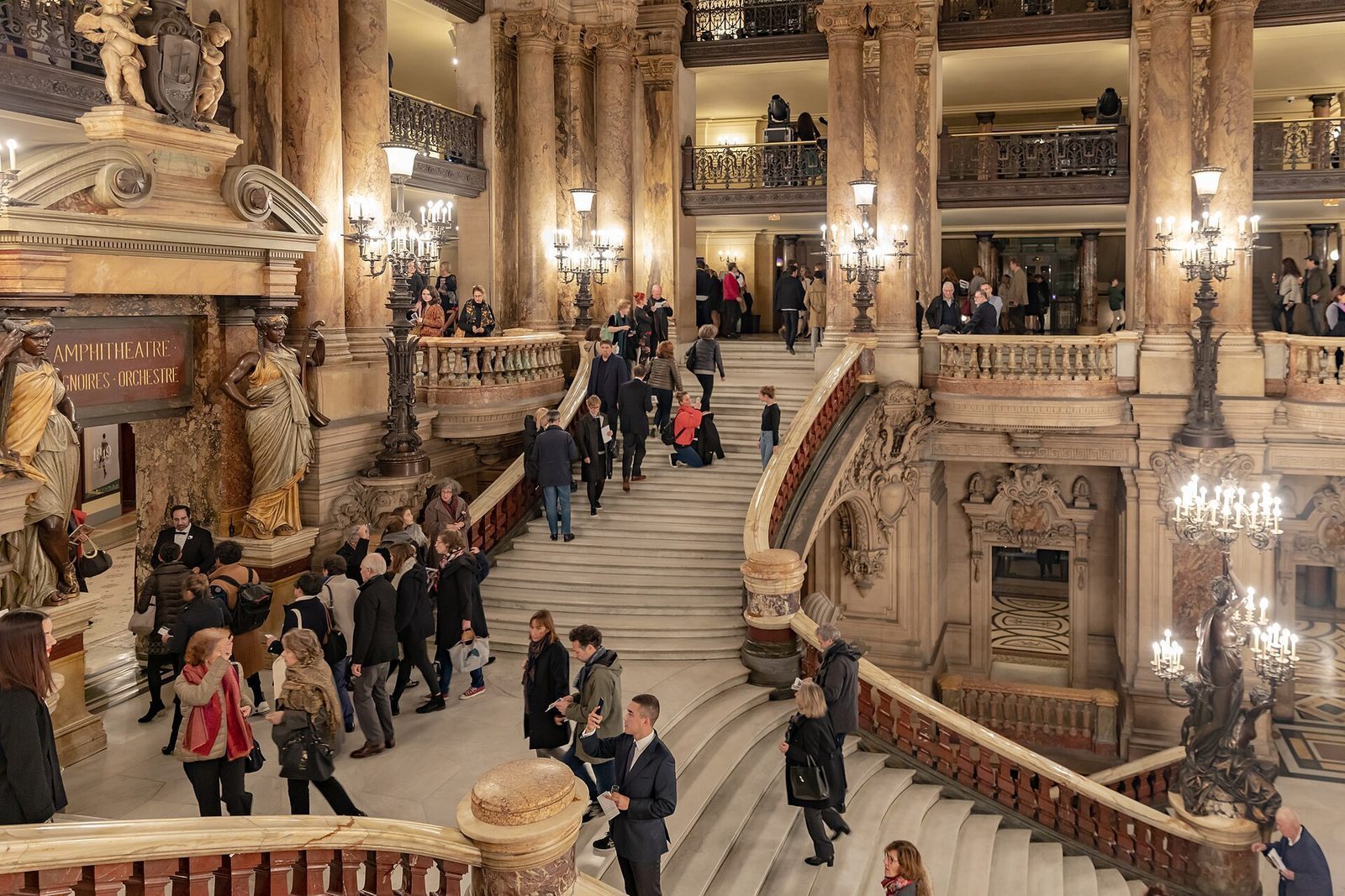 Den store marmortrappen i Palais Garnier med publikum på vei opp mellom kandelabre og balkonger