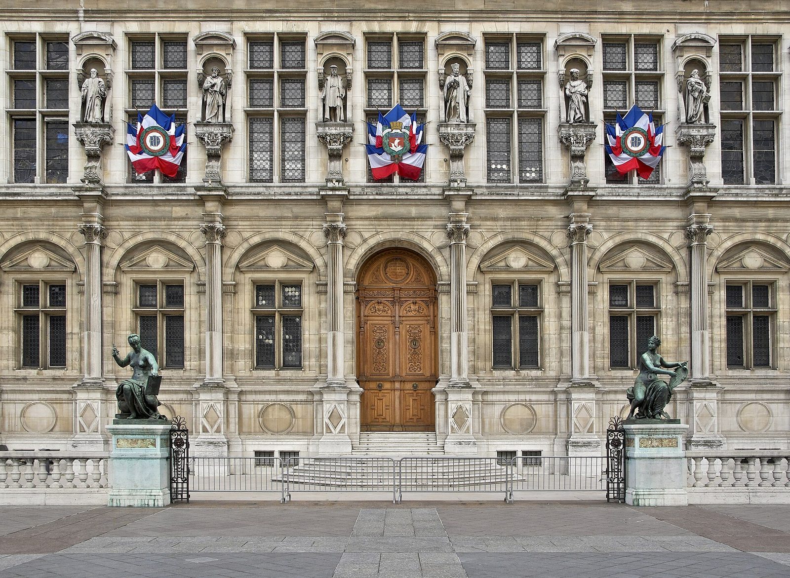 Hovedinngangen til Hôtel de Ville med skulpturer i nisjer, bronsefigurer og franske flagg