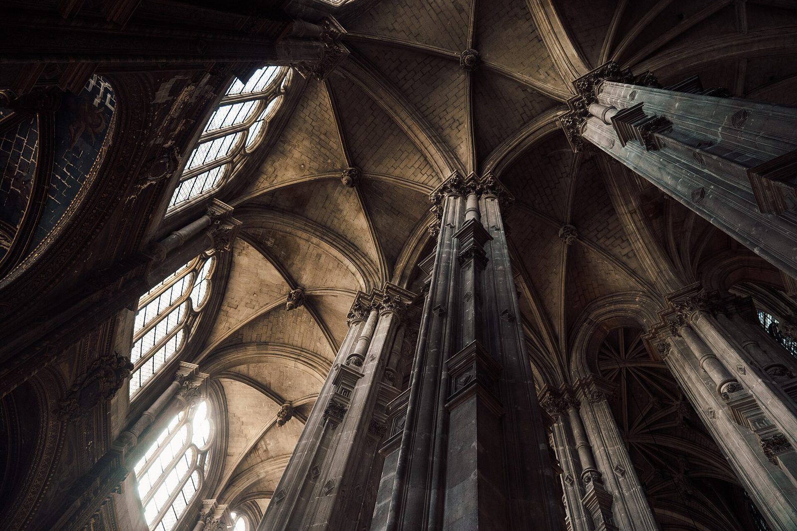 Gotiske ribbehvelv og høye søyler sett nedenfra inne i kirken Saint-Eustache i Paris