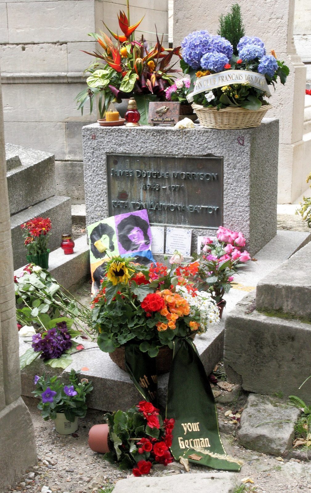 Jim Morrisons grav på Père-Lachaise dekket av blomsterbuketter, lys og hilsener fra besøkende