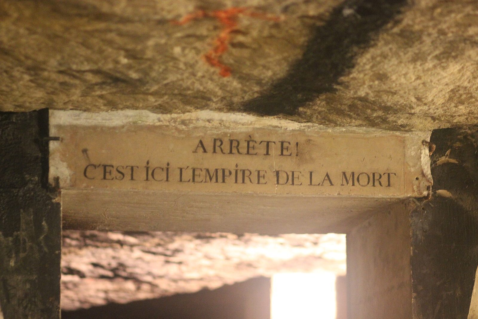 Portalen i katakombene med den innhugde advarselen «Arrête! C'est ici l'empire de la Mort» over åpningen