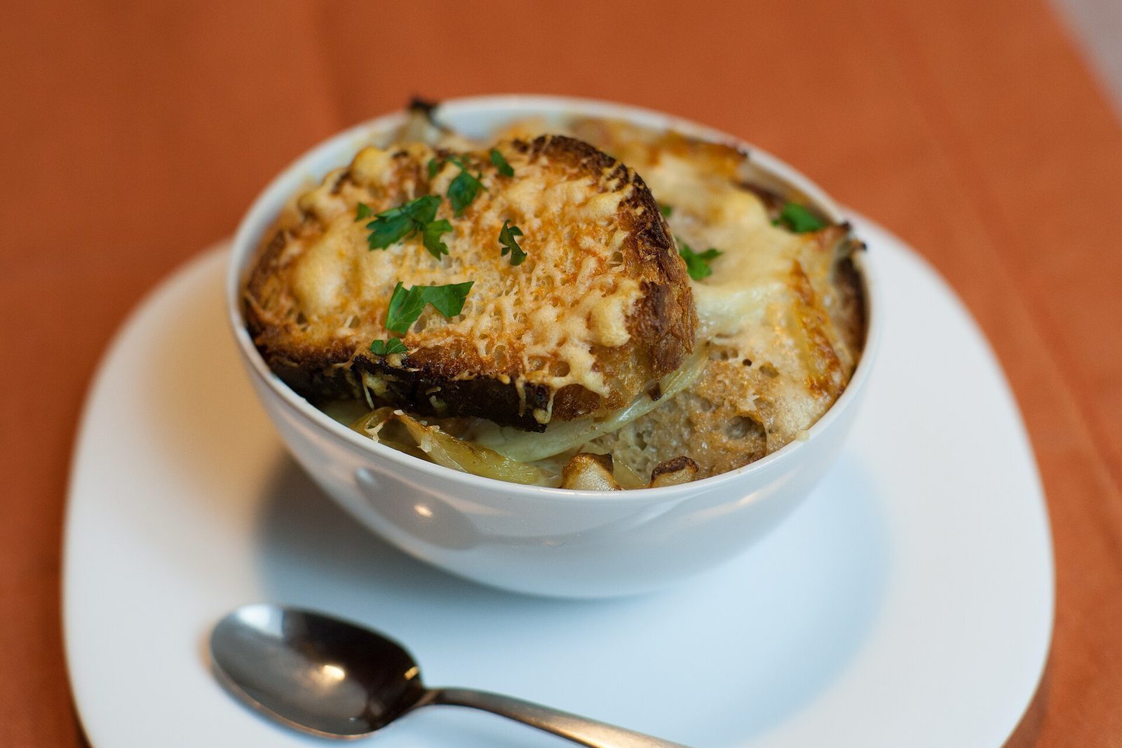 Løksuppe gratinert med brød og smeltet ost i en leirkopp