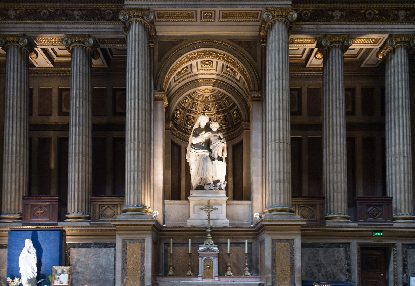 Sidealter inne i La Madeleine med marmorskulptur av Maria med barnet under en forgylt kassettbue