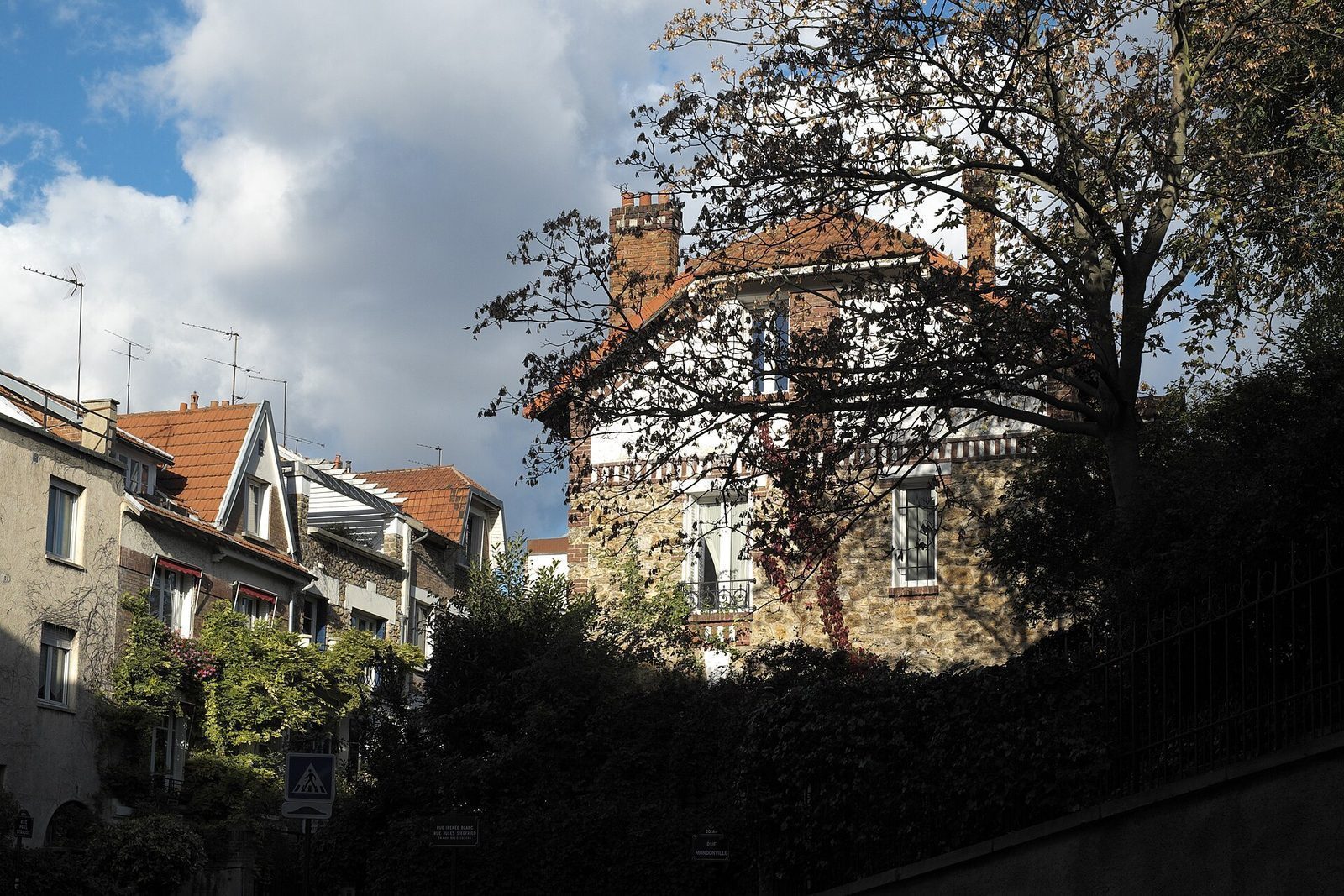 Små toetasjes hus med teglstak og klatreplanter i La Campagne à Paris nær Porte de Bagnolet