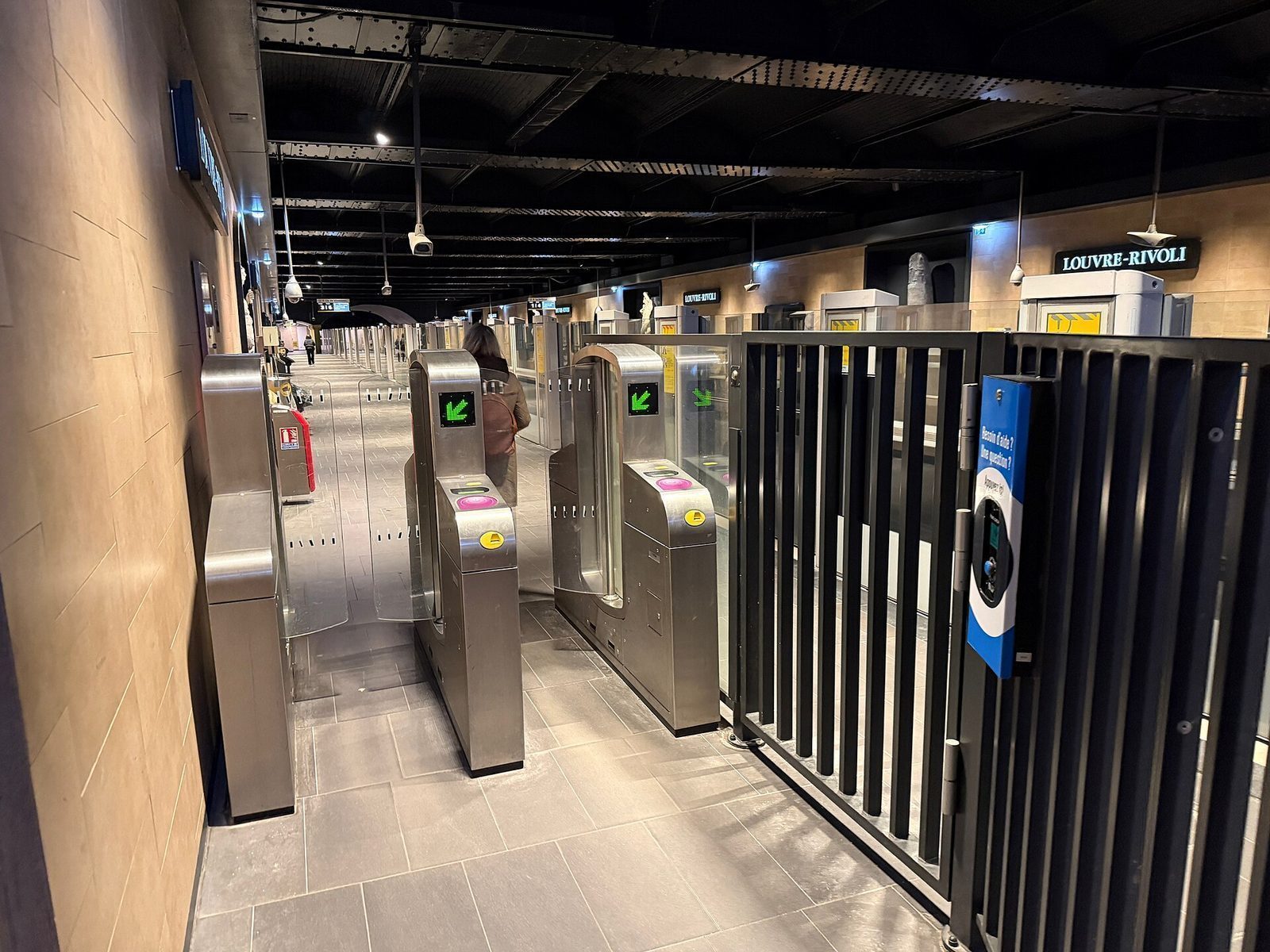 Billettsperrer på metrostasjonen Louvre-Rivoli, med en reisende på vei gjennom porten