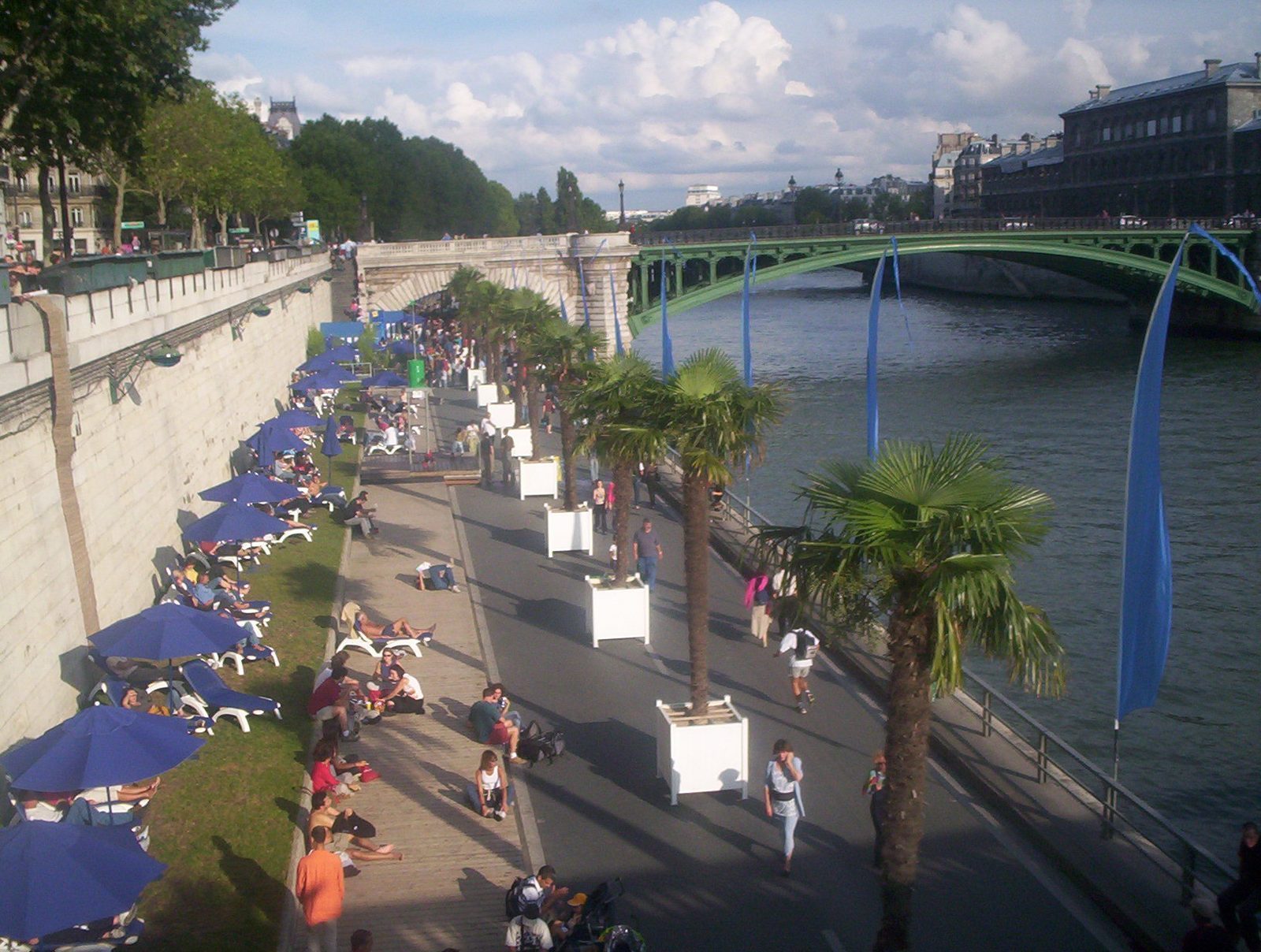 Solsenger, parasoller og palmer på en Seine-bredde under Paris Plages