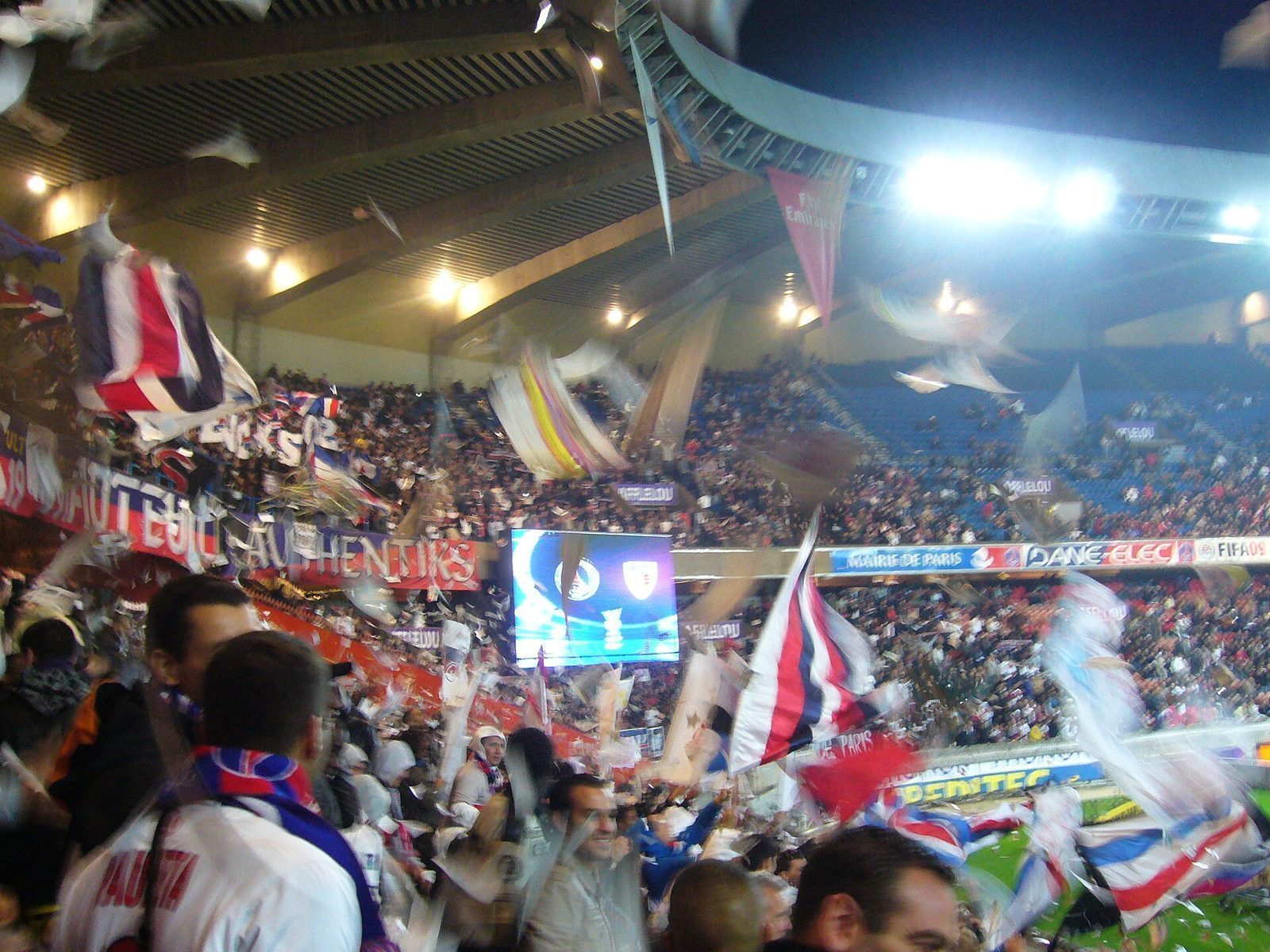 Supportertribunen Virage Auteuil i Parc des Princes med flagg, bannere og papirkonfetti i lufta