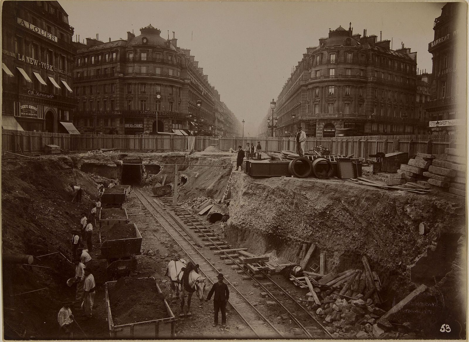 Åpen byggegrop for metroen ved Place de l'Opéra rundt 1900 med arbeidere, hest og lastevogner