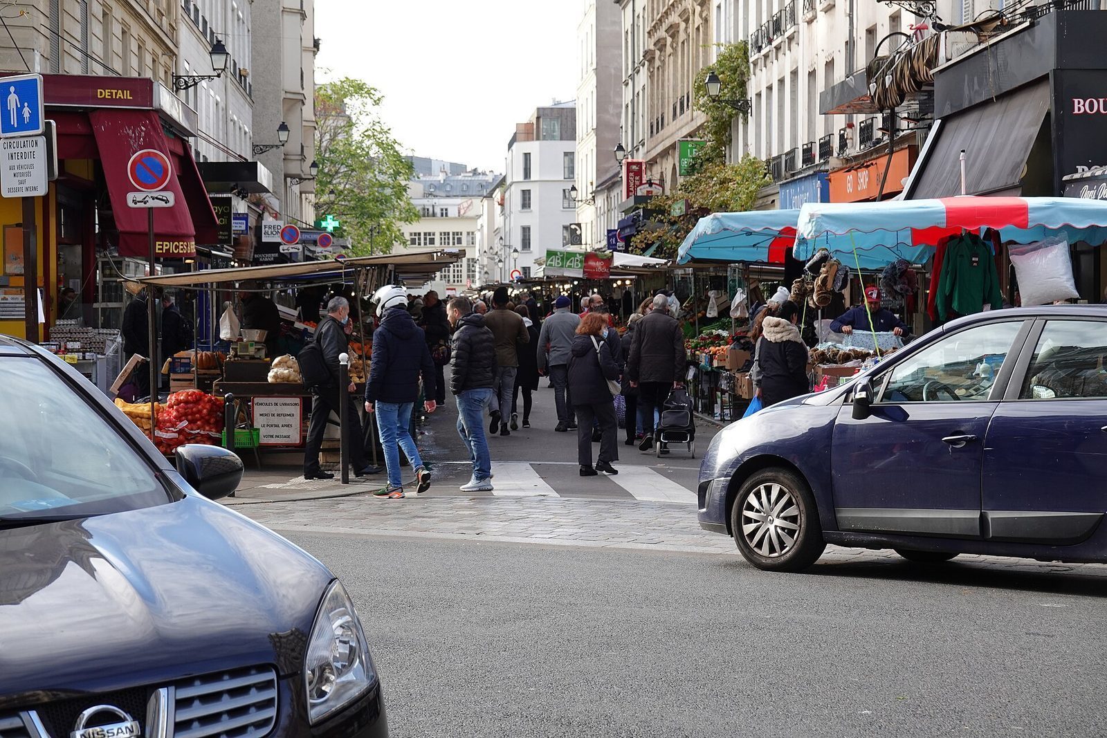 Gatemarkedet i Rue d'Aligre i 12. arrondissement med boder, folk og butikker på begge sider