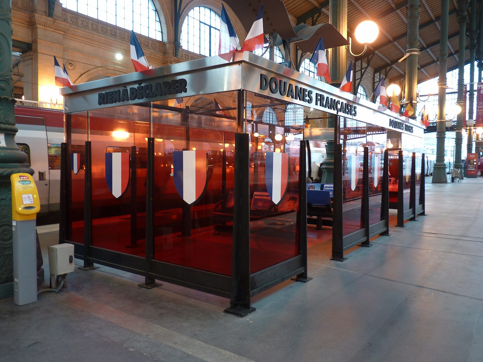 Tollpost i rødt glass merket «Douanes françaises» og «Rien à déclarer» på perrongen i Gare du Nord i Paris