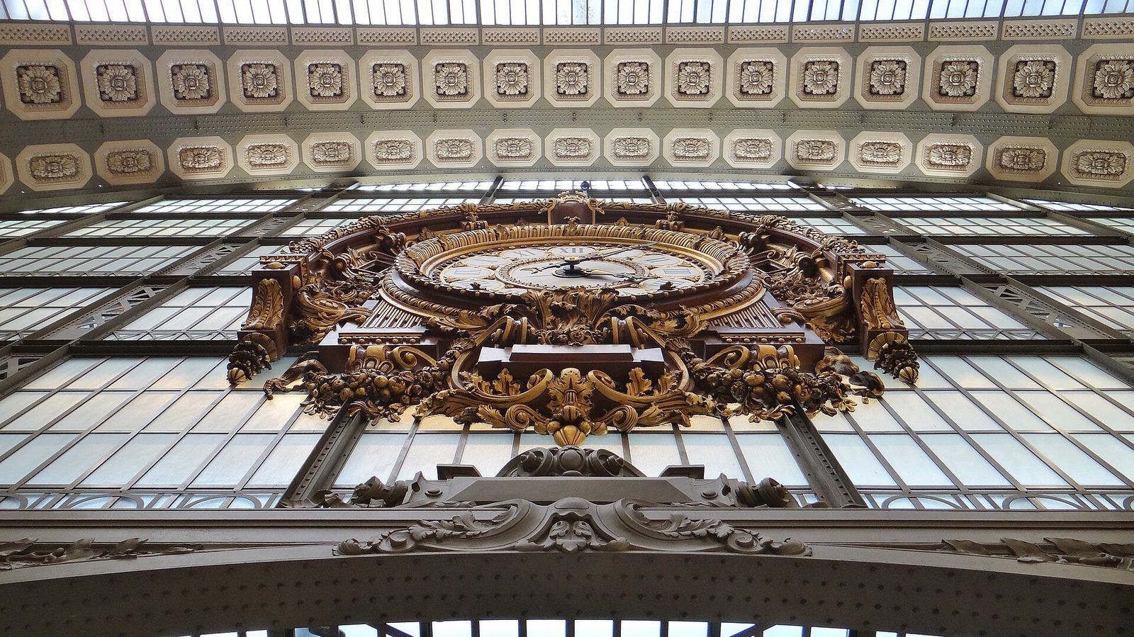 Den store forgylte stasjonsklokken sett nedenfra under glasstaket i Musée d'Orsay