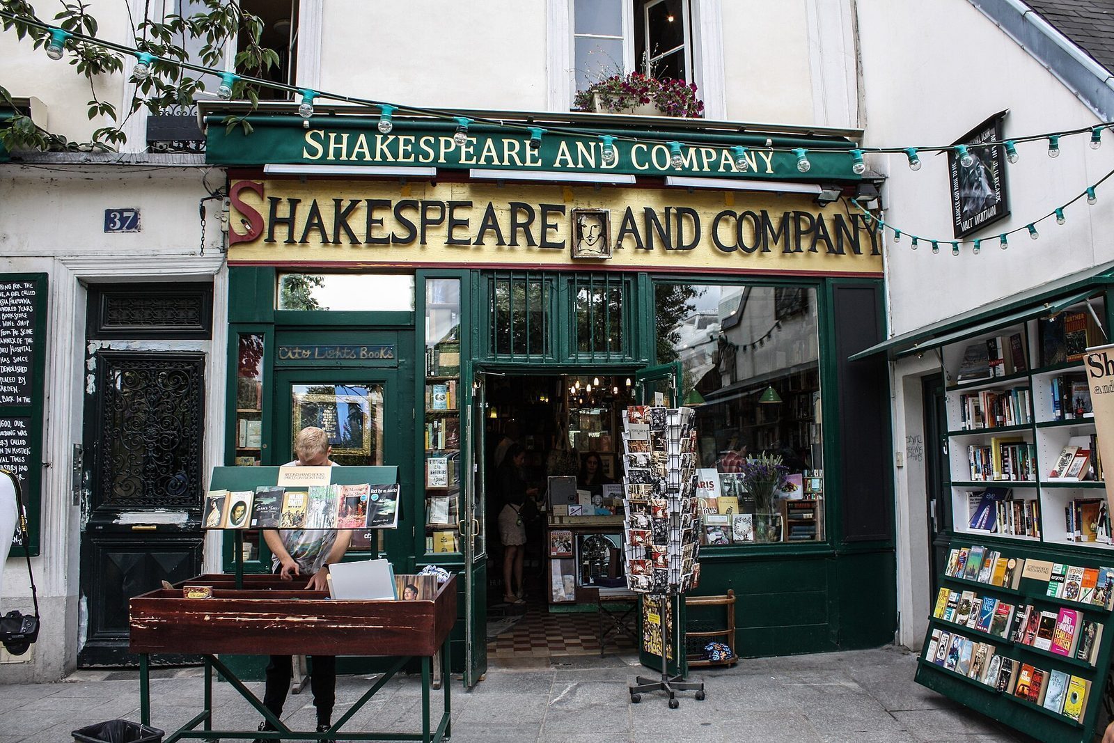 Den grønne fasaden til bokhandelen Shakespeare and Company med bokbord på fortauet