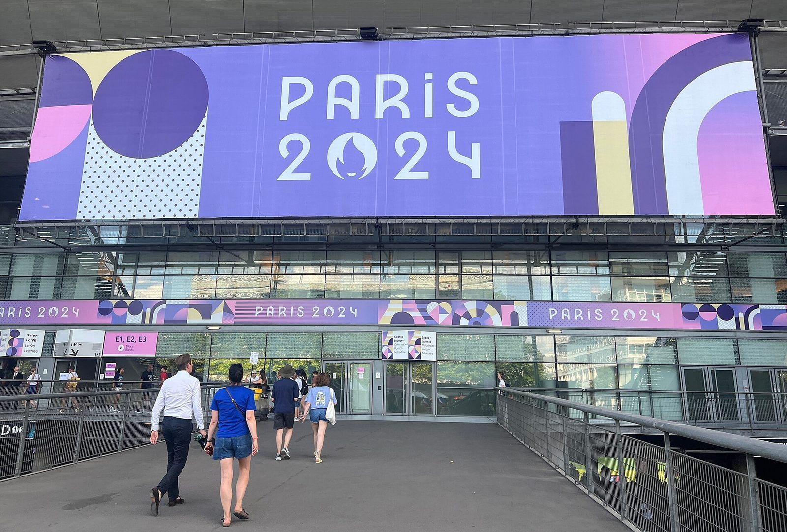 Inngangspartiet til Stade de France dekket av Paris 2024-banner i lilla og rosa under OL